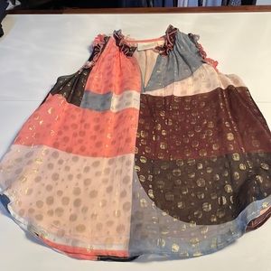 Flowy summer top . With metallic touches and frills around armholes and collar .